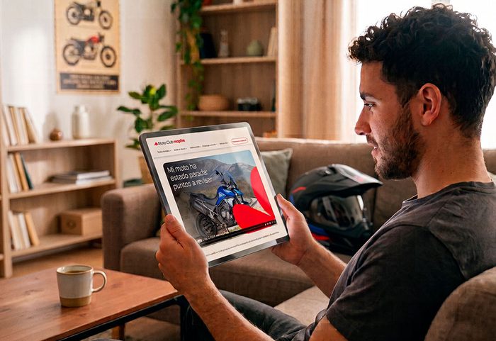 Hombre consultando los contenidos de Moto Club Mapfre en una tablet desde el sofá